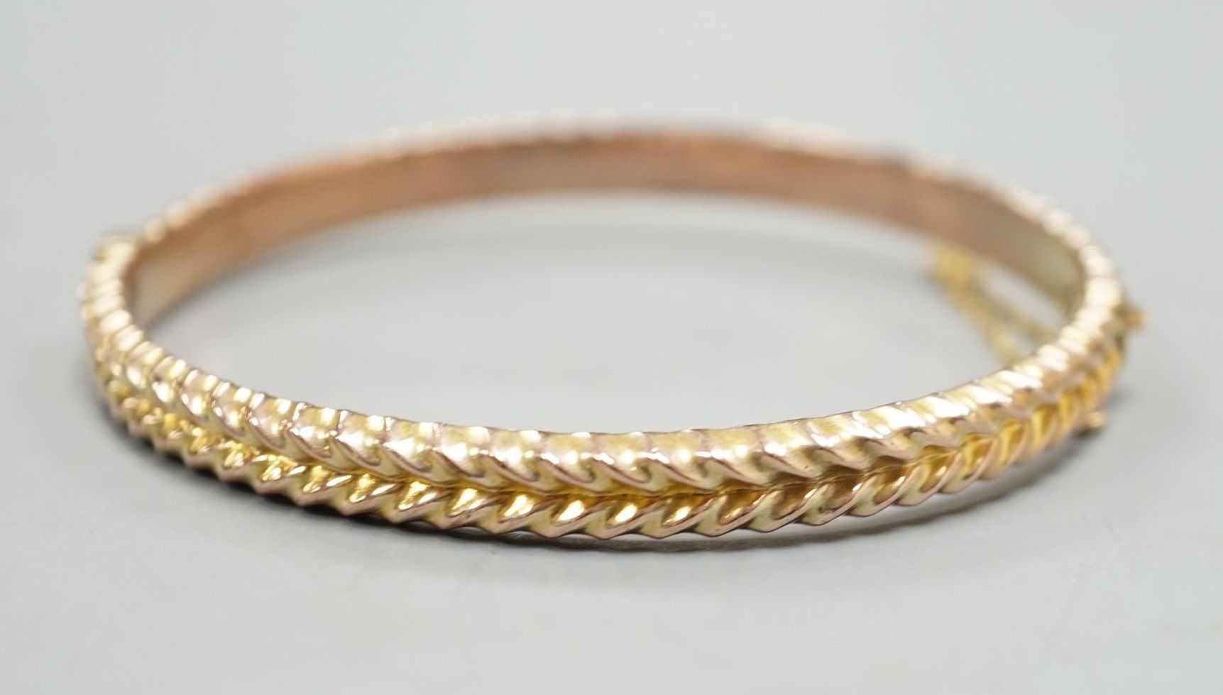 An Edwardian 9ct hinged bangle, 58mm, 8.4 grams.